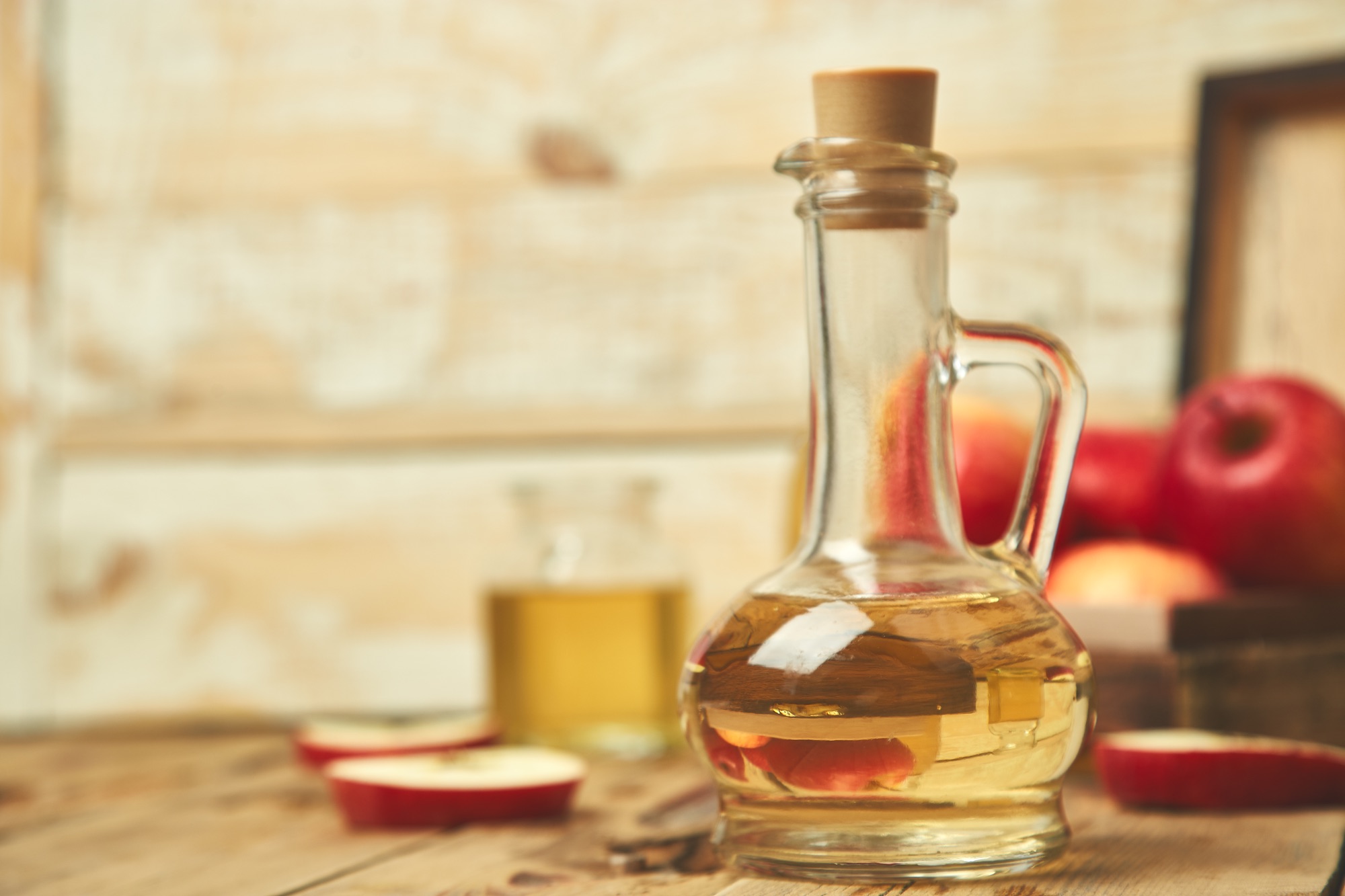 Essigflasche neben Pflastersteinen als Hausmittel gegen Unkraut